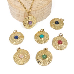 Puede incluir: Siete colgantes de oro con gemas de colores diferentes en el centro. Cada colgante tiene un diseño texturizado en forma de sol.