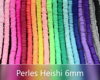 Op de afbeelding: Een selectie van kleurrijke 6 mm ronde polymer clay kralen, ook wel Heishi kralen genoemd, gerangschikt in rijen. De kralen zijn in een regenboog van kleuren, waaronder roze, rood, oranje, geel, groen, blauw, paars en wit.