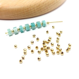 Peut inclure: Un brin de perles de pierres précieuses vert clair et blanc avec des accents dorés, et un tas de petites perles dorées.