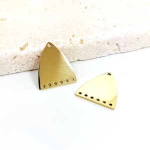 May include: Two gold-colored triangle-shaped metal charms with a row of small holes along the bottom edge.