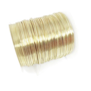 Puede incluir: Una bobina de alambre de color dorado. El alambre está enrollado apretado y listo para ser usado para manualidades o la fabricación de joyas.