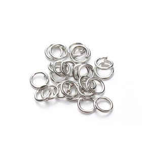 Peut inclure: Un tas de anneaux de jonction argentés, un type de composant de bijouterie utilisé pour relier les chaînes, les cordons et autres composants de bijoux.