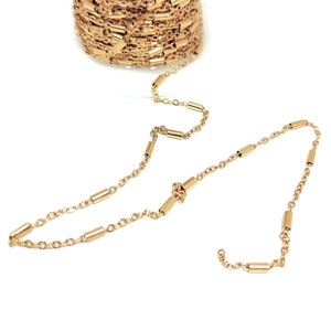 Peut inclure: Un collier en chaîne dorée avec de petites perles cylindriques. La chaîne est faite d'un design délicat et lié.