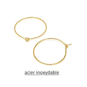 Puede incluir: Dos pendientes de aro dorados de acero inoxidable.