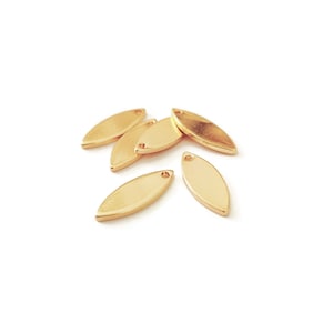 Peut inclure: Un groupe de six breloques en métal en forme de feuille de couleur dorée avec un petit trou en haut pour les attacher à des bijoux ou d'autres objets artisanaux.