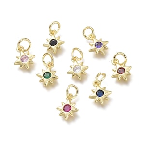 May include: Eight gold star charms with different coloured gemstones in the centre. The charms have a loop at the top for attaching to a necklace or bracelet.