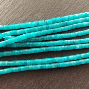 May include: A strand of turquoise blue gemstone beads. The beads are square shaped and have a slightly frosted finish.