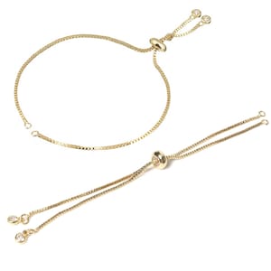 Peut inclure: Deux bracelets ajustables en or avec de petites pierres claires aux extrémités. Chaque bracelet a une perle ronde en or au centre.