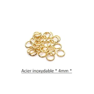 Op de afbeelding: Een stapel gouden metalen springringen, 4 mm in diameter. Acier inoxydable * 4mm *