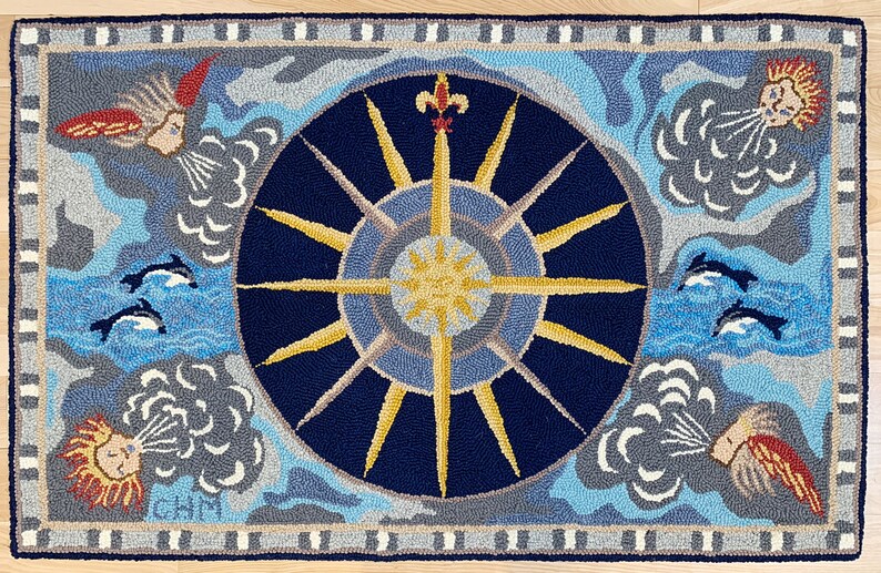 K&ouml;nnte beinhalten: Ein blauer und goldener Teppich mit einem Sonnenstrahl-Design in der Mitte. Der Sonnenstrahl ist von vier Wolken mit Gesichtern und vier Delfinen umgeben, die im Wasser schwimmen. Der Teppich hat einen grauen und wei&szlig;en Rand.