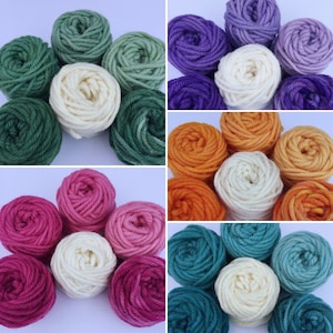 May include: Six sets of yarn balls in different color combinations. Each set includes three balls of yarn, one white, one ombre, and one solid color. The colors include green, purple, orange, pink, and teal.