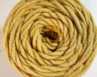 May include: A skein of yellow yarn wound into a tight coil. The yarn is a soft, fuzzy texture.