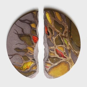 Peut inclure: Deux pièces de décoration murale en céramique, chacune en demi-cercle, avec une fissure au milieu. Les pièces sont peintes avec un motif abstrait brun, or et rouge.