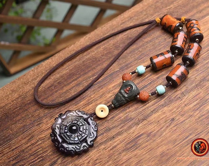 tigle, pendant, traditional Tibetan protection amulet. Work on agate necklace carved with Buddhist symbols. Buddha