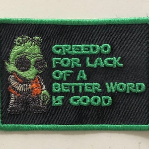 Può includere: Toppa ricamata verde con un personaggio alieno dei cartoni animati e il testo "Greedo for lack of a better word is good".