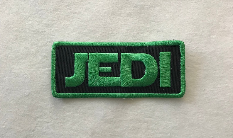 May include: Green embroidered patch with the word "JEDI" in black outlined letters.