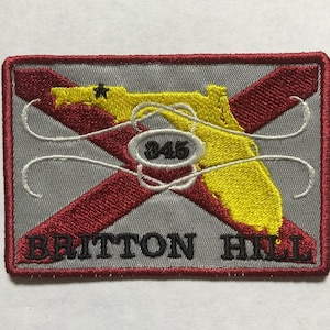 May include: Embroidered patch with a red and yellow Florida state outline, a white star, and the text "BRITTON HILL" in black. The patch also features a white circle with the number "345" in black.