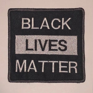 May include: Black Lives Matter patch with white text on a black background.