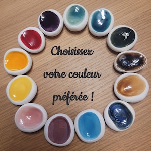 Peut inclure: Une disposition circulaire de douze petits plats en céramique avec une bordure blanche et une variété de couleurs brillantes à l'intérieur. Les couleurs comprennent le rouge, le jaune, le bleu et le vert. Le texte central dit "Choisissez votre couleur préférée !"