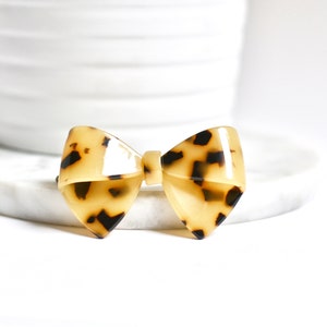 Peut inclure: Un nœud de cheveux en forme de pointe avec un motif de carapace de tortue brun et noir.