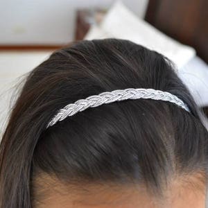 Peut inclure: Un serre-tête tressé argenté pour cheveux de femme.