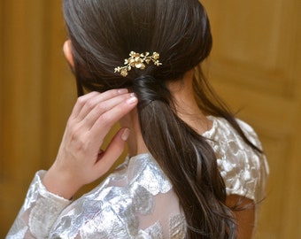 Foto del pelo, joya de la cabeza de la boda, pico de bollo, flor, hoja, rama. Delicada joya de oro fina y refinada, novia. Boheme romántico