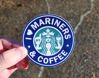 May include: A blue and green round sticker with the text "I love Mariners & Coffee" and a stylized Starbucks logo with a woman holding a cup of coffee. The text "#1" is on the woman's glove.