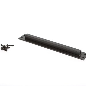 May include: A black metal cabinet pull with a rectangular base and a square handle. Several black screws are next to the pull. The hardware is set against a white background.