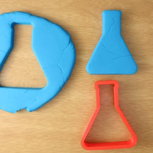 May include: Two blue plastic beakers, one solid and one with a cut-out shape, and a red plastic beaker with a cut-out shape.