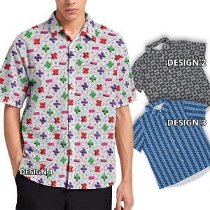 Può includere: Tre diversi design per una camicia a maniche corte con bottoni. Il design 1 presenta uno sfondo bianco con un motivo ripetitivo di simboli matematici colorati. Il design 2 presenta uno sfondo grigio con un motivo ripetitivo di simboli matematici neri. Il design 3 presenta uno sfondo blu con un motivo ripetitivo di simboli matematici bianchi. Il testo "DESIGN 1", "DESIGN 2" e "DESIGN 3" è visibile su ogni camicia.