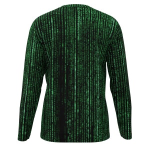 May include: Long-sleeved top with a black and green digital rain design. The pattern consists of vertical lines of green characters on a black backdrop, giving a tech-inspired look. The top has a crew neck and long sleeves.