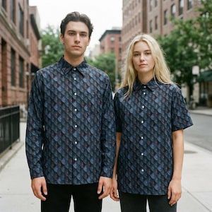 May include: Two button-down shirts with a repeating geometric pattern in shades of blue, gray, and burgundy. One shirt has long sleeves, and the other has short sleeves. Both shirts have white buttons and collars.