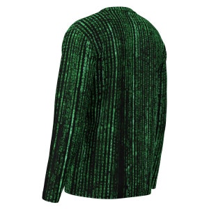 May include: Black long-sleeved top with a green digital rain pattern. The design features vertical lines of green characters, creating a matrix-like effect. The top has a crew neck and is made of a soft material.