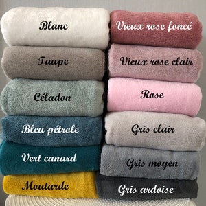 May include: A stack of 12 soft, plush fabric swatches in various colors, including white, taupe, celadon, blue, green, mustard, pink, and gray. Each swatch has a French word label describing the color, such as "Blanc", "Taupe", "C&eacute;ladon", "Bleu p&eacute;trole", "Vert canard", "Moutarde", "Rose", "Gris clair", "Gris moyen", and "Gris ardoise".