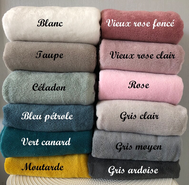 May include: A stack of 12 soft, plush fabric swatches in various colors, including white, taupe, celadon, blue, green, mustard, pink, and gray. Each swatch has a French word label describing the color, such as "Blanc", "Taupe", "C&eacute;ladon", "Bleu p&eacute;trole", "Vert canard", "Moutarde", "Rose", "Gris clair", "Gris moyen", and "Gris ardoise".