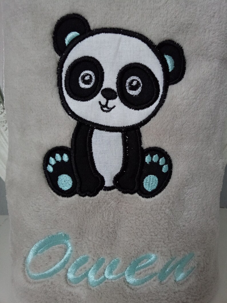 May include: A gray plush blanket with an embroidered panda bear and the name "Owen" in light blue thread.