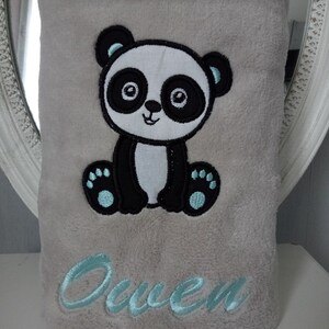 May include: A gray plush blanket with a black and white embroidered panda bear and the name "Owen" in light blue embroidery.