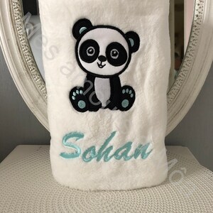 May include: White plush blanket with a black and white embroidered panda bear and the name "Sohan" in light blue embroidery.