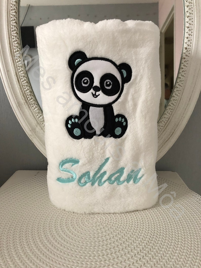 May include: White plush blanket with a black and white embroidered panda bear and the name "Sohan" in light blue embroidery.