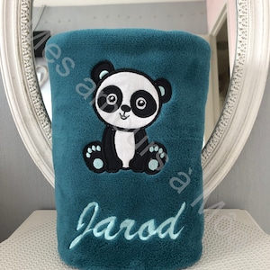 May include: Teal blue fleece blanket with an embroidered panda bear and the name "Jarod" in light blue thread.