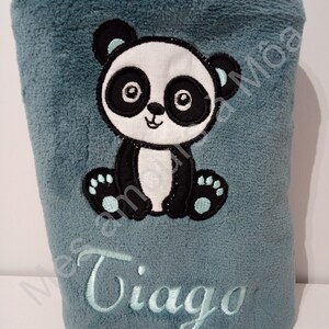 May include: A soft blue plush blanket with an embroidered panda bear and the name "Tiago" in light blue thread.
