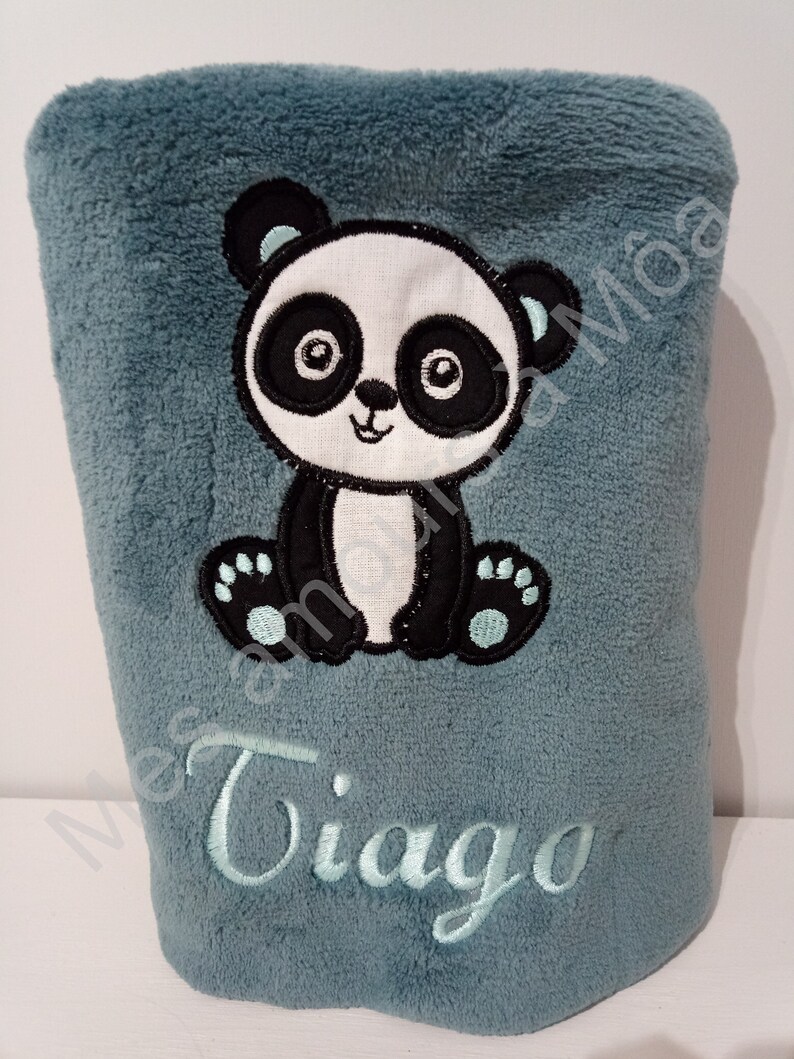 May include: A soft blue plush blanket with an embroidered panda bear and the name "Tiago" in light blue thread.