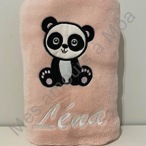 May include: A pink plush blanket with a black and white panda embroidered on it. The blanket has the name "Lena" embroidered on it in white.