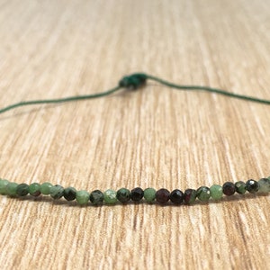 May include: A delicate green and red gemstone necklace with a simple adjustable cord closure. The necklace is made of small, faceted beads and is perfect for layering.