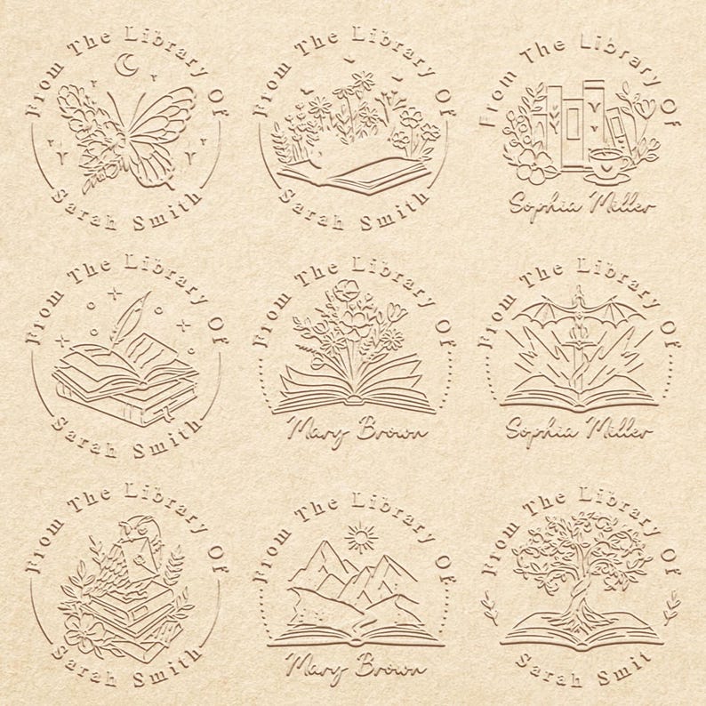 May include: Nine round, brown, rubber stamps with a white design. Each stamp features a different image, including a butterfly, flowers, books, a quill pen, a mountain range, and a tree. The text "From The Library Of" is on each stamp, along with a name.