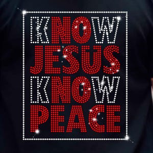 May include: Black t-shirt with the text "KNOW JESUS KNOW PEACE" in a rectangular design. The words "KNOW" and "PEACE" are in white, while "JESUS" is in red. The text is made of small, sparkling embellishments.