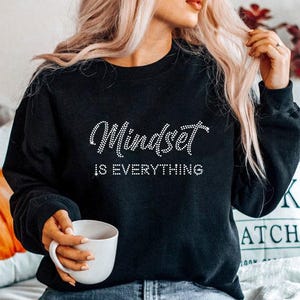 May include: Black sweatshirt with the text "Mindset is Everything" in white rhinestones.