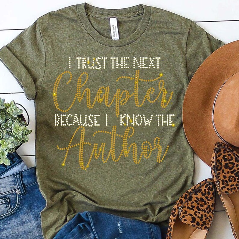 Puede incluir: Una camiseta verde con el texto "I trust the next chapter because I know the Author" en letras doradas de purpurina.