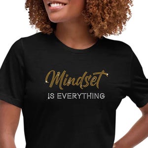 May include: A black t-shirt with the text "Mindset is Everything" in gold rhinestones.