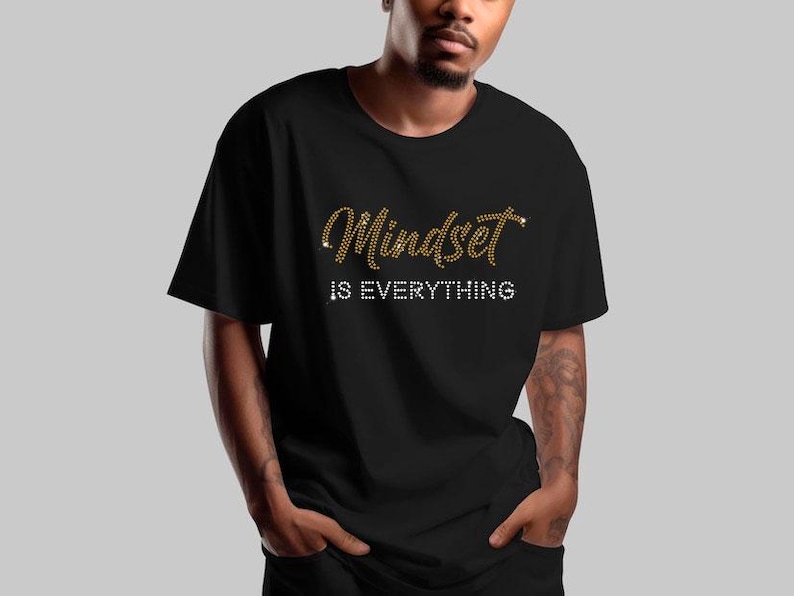 May include: A black t-shirt with the text "Mindset is Everything" in gold and white rhinestones.